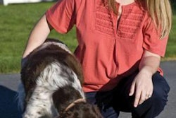 Callie Novak watches the dog enjoy Dynamite's Ultimate Dog Food