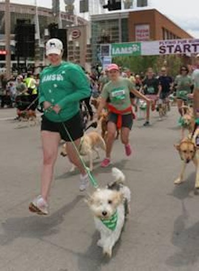 Meredith Leslie, of P&G, runs with Pawl Griffin, Iams VP of Canine Communications, during the Iams Flying Fur dog run in downtown Cincinnati, May 3, 2014. More than 500 dogs and owners ran in the two-mile race as part of races taking place during the Flying Pig Marathon weekend events. Iams Bowls of Love will be donating a bag of petfood for each dog running in the event to the SPCA in Cincinnati. (Tom Uhlman/AP Images for Iams)