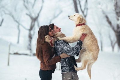 Young Couple Holding Dog Outside