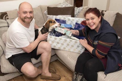 Adam Colvin, Chester and Jo Little unwrap an early Christmas present. | Photo by Fish4Dogs