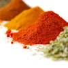 Heaps of various ground spices on white background