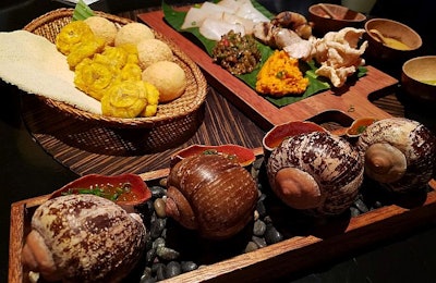 Giant snails, smoked paiche fish, paiche skin chicharrones, plantain chips (tostones), yuca flat bread and other items at Amaz restaurant in Lima, Peru. August 26, 2019 (Tim Wall)
