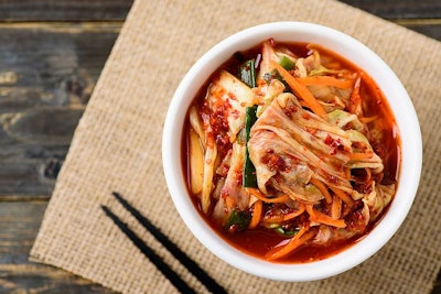 Kimchi cabbage in a bowl with chopsticks (Buppha Wut, Bigstock.com)