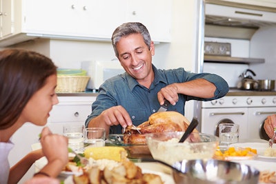 Dad Carving Roast Chicken At Table