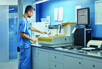 Male veterinarian working in laboratory. Vet doctor is examining sample at animal hospital. He is wearing uniform.