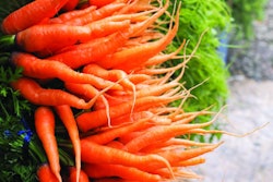 Close up heap of bunch baby carrots in the market. Orange vegetable.