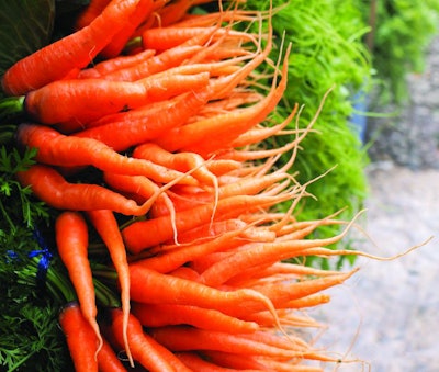 Close up heap of bunch baby carrots in the market. Orange vegetable.