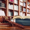 Law books and a gavel on the desk in the library.