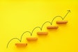 Rising arrow on staircase on yellow background. Growth, increasing business, success process concept. Copy space