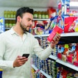 Latin American man looking at the checklist on smartphone to get his groceries at the market - Consumerism concepts