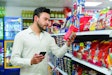 Latin American man looking at the checklist on smartphone to get his groceries at the market - Consumerism concepts