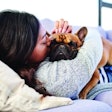 Shot of a young woman relaxing with her dog at home