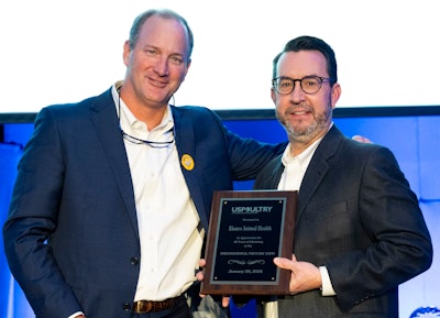 Jonathan Martin from Elanco Animal Health accepts the long-time exhibitor plaque from Mikell Fries (left), Claxton Poultry Farms and USPOULTRY chair.