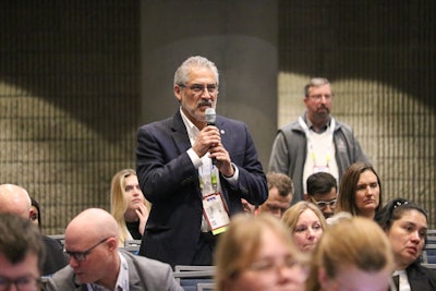 An attendee poses questions to a speaker during AFIA's Pet Food Conference.