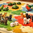 A Game Board With Tiny Plastic Dogs, Cats, Turtles And Parrots As The Game Pieces