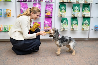 Elisabetta Pierangelo, global vice president R&D, Mars Pet Nutrition, hands out PEDIGREE Dentastix Light to dogs at a Mars pet-friendly office.
