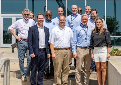 Simmons Foods personnel stand with Arkansas Gov. Sarah Huckabee Sanders.