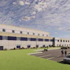 Modern industrial warehouse facility with multi-story design, parking area, and landscaped grounds under cloudy sky