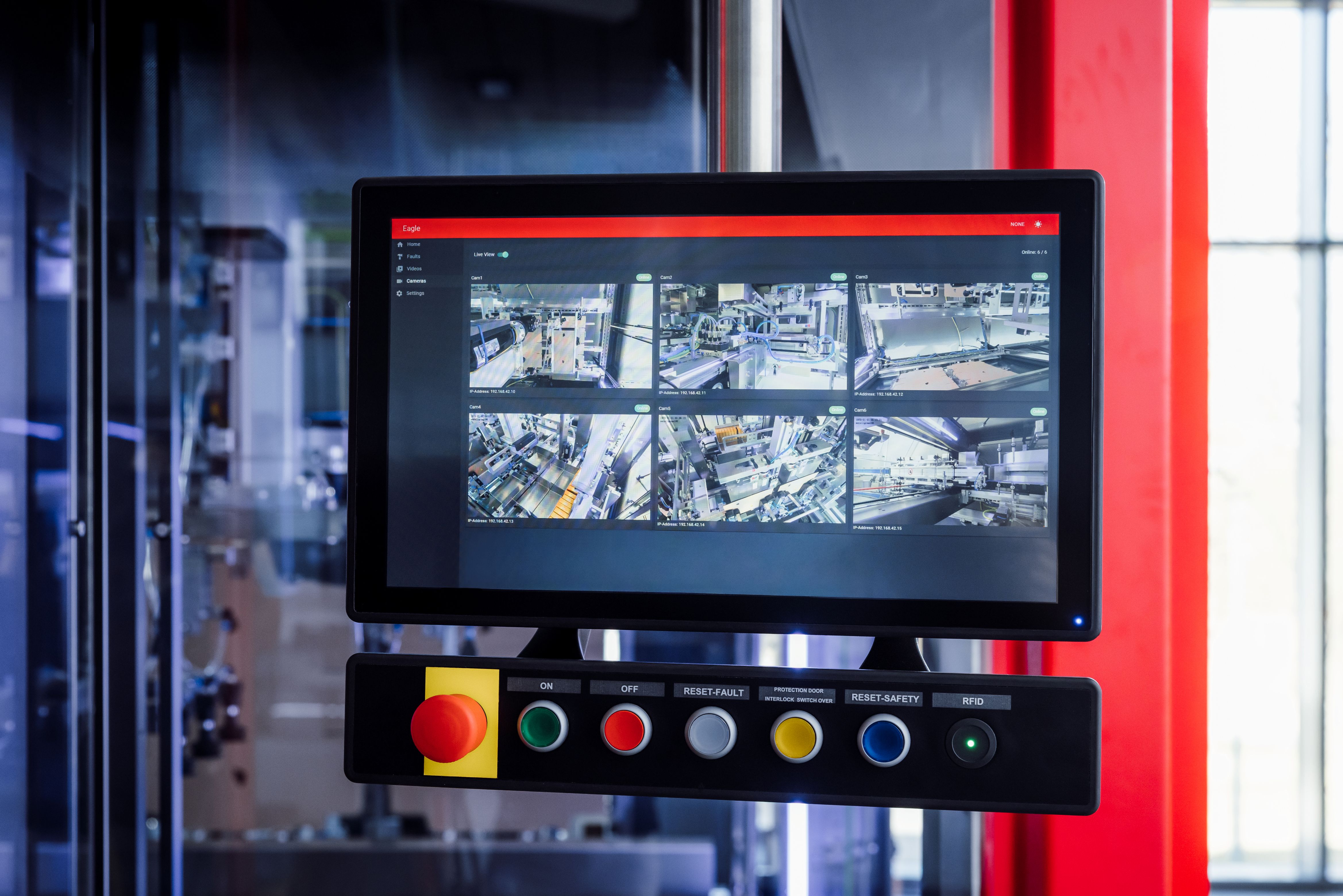 Surveillance monitoring system with display screen showing aerial city camera feeds and control panel with colored buttons