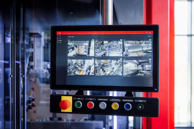 Surveillance monitoring system with display screen showing aerial city camera feeds and control panel with colored buttons