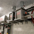 Industrial WEDA vacuum lifting systems mounted on ceiling rails in warehouse facility