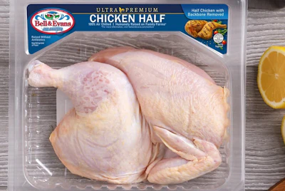 Bell & Evans Ultra Premium chicken half package with raw poultry on wooden surface