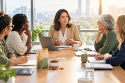 Professional women in business meeting around wooden table with city skyline view in modern office