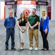 Four Petco employees standing together in store entrance with welcome signage and pet food branding visible behind them