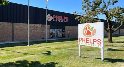 Phelps Pet Products storefront with white ground sign featuring orange paw print logo and building signage