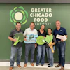 Five volunteers holding food advocacy signs at Greater Chicago Food Depository