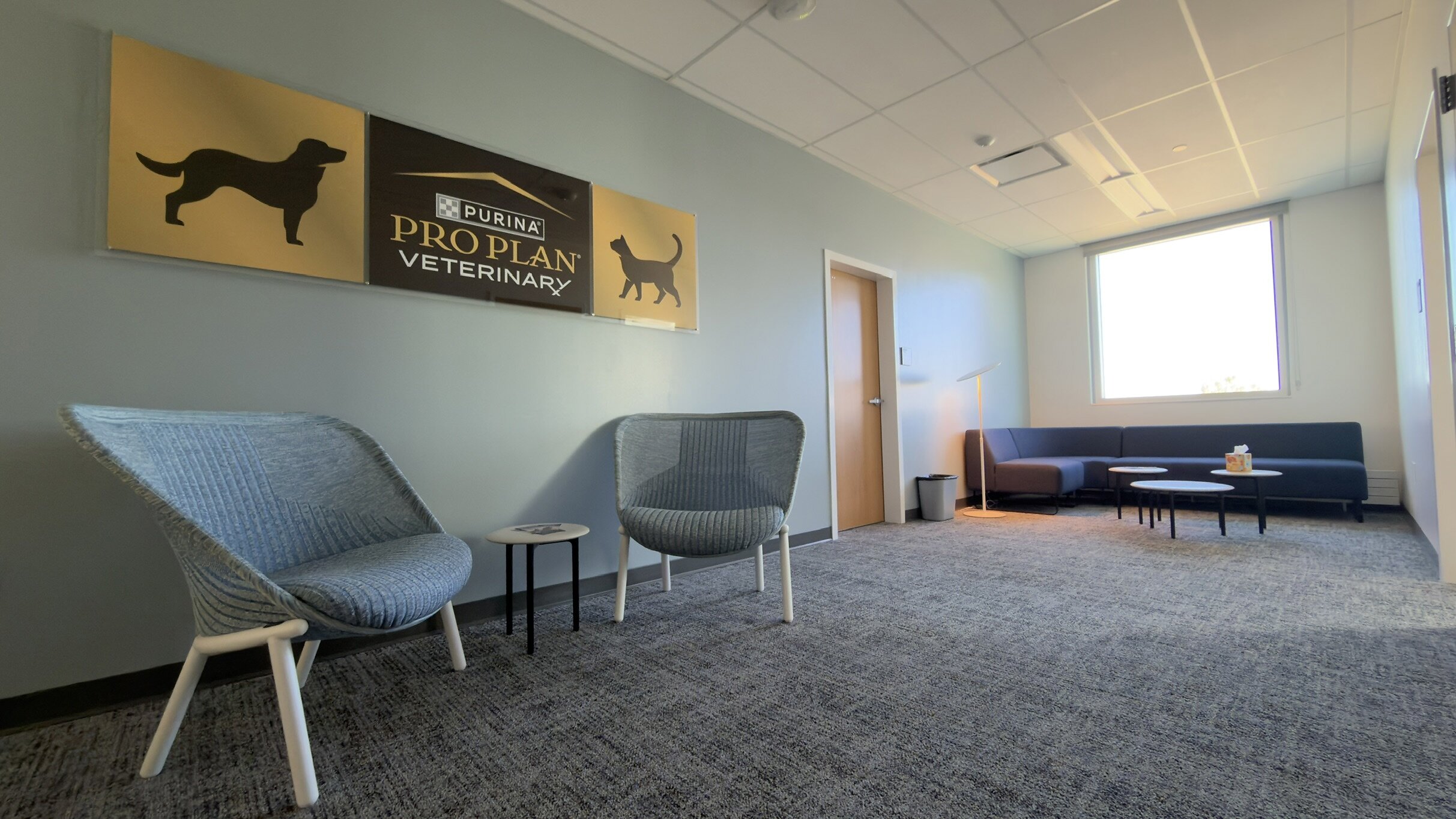 Modern veterinary clinic waiting room with Purina Pro Plan Veterinary signage and contemporary furniture