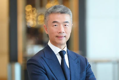 Professional man in navy suit and tie against blurred office background