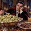 Vampire character in formal attire dining in gothic cathedral with candles, grapes, and wine